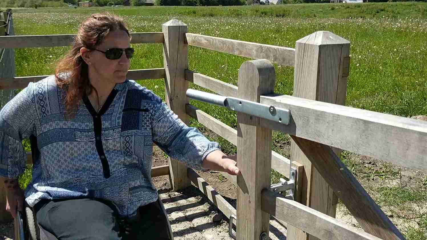 En dame åpner grinden til en HandyGate