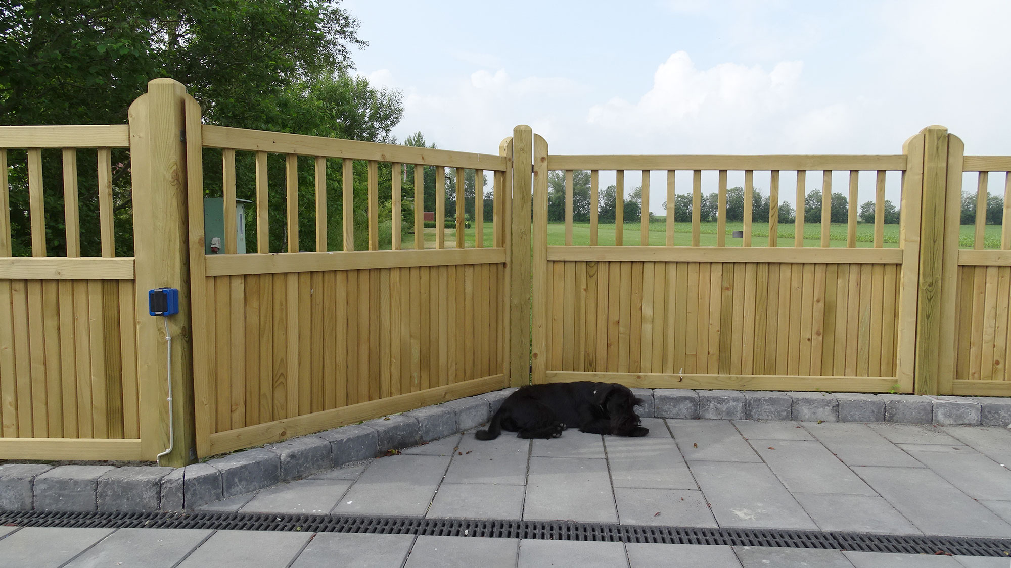En hund som tar seg en lur foran et «Country Garden»-gjerde