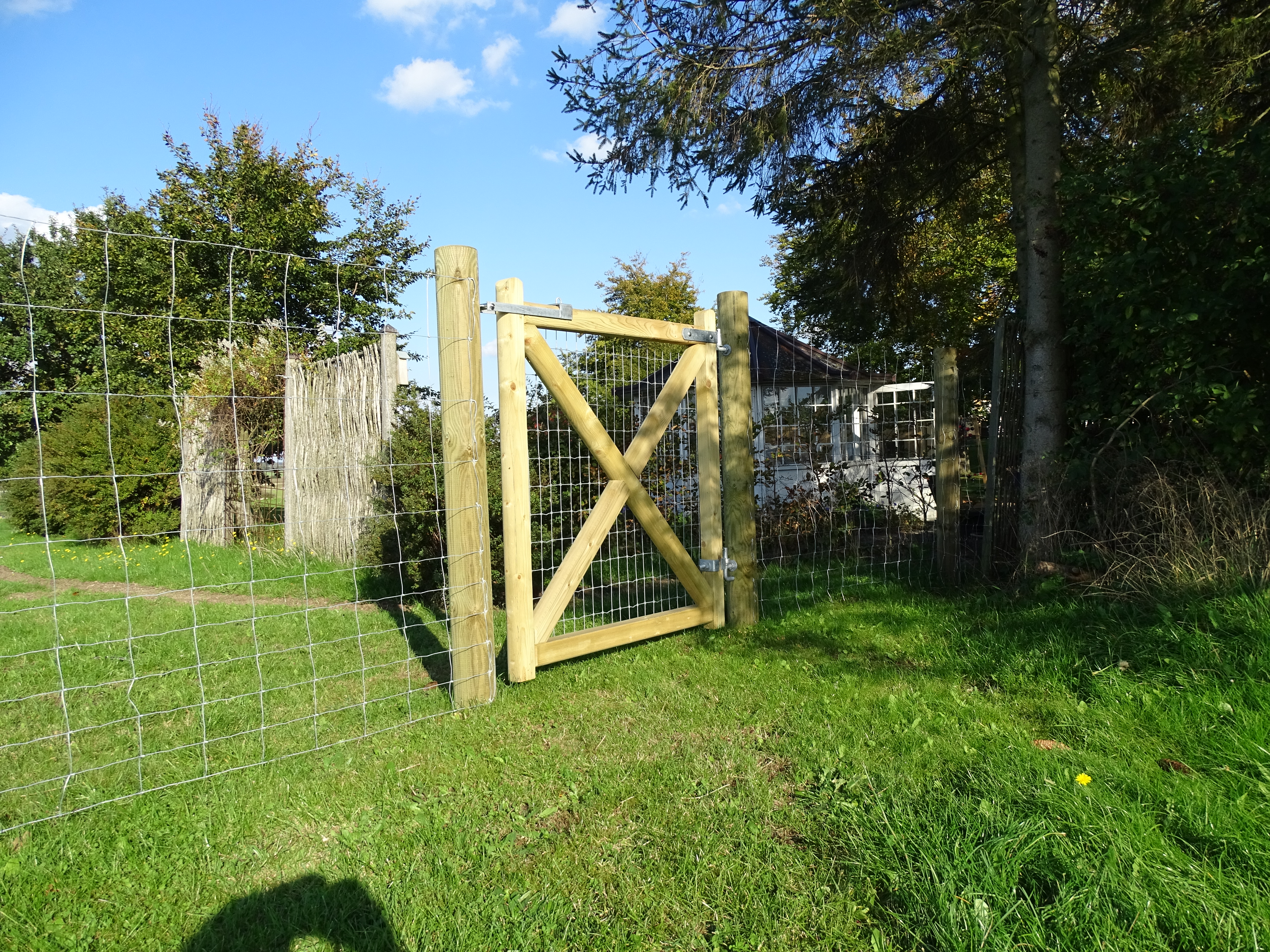 I en hage er det montert en «Country Estate»-grind. I bakgrunnen kan du se huset.