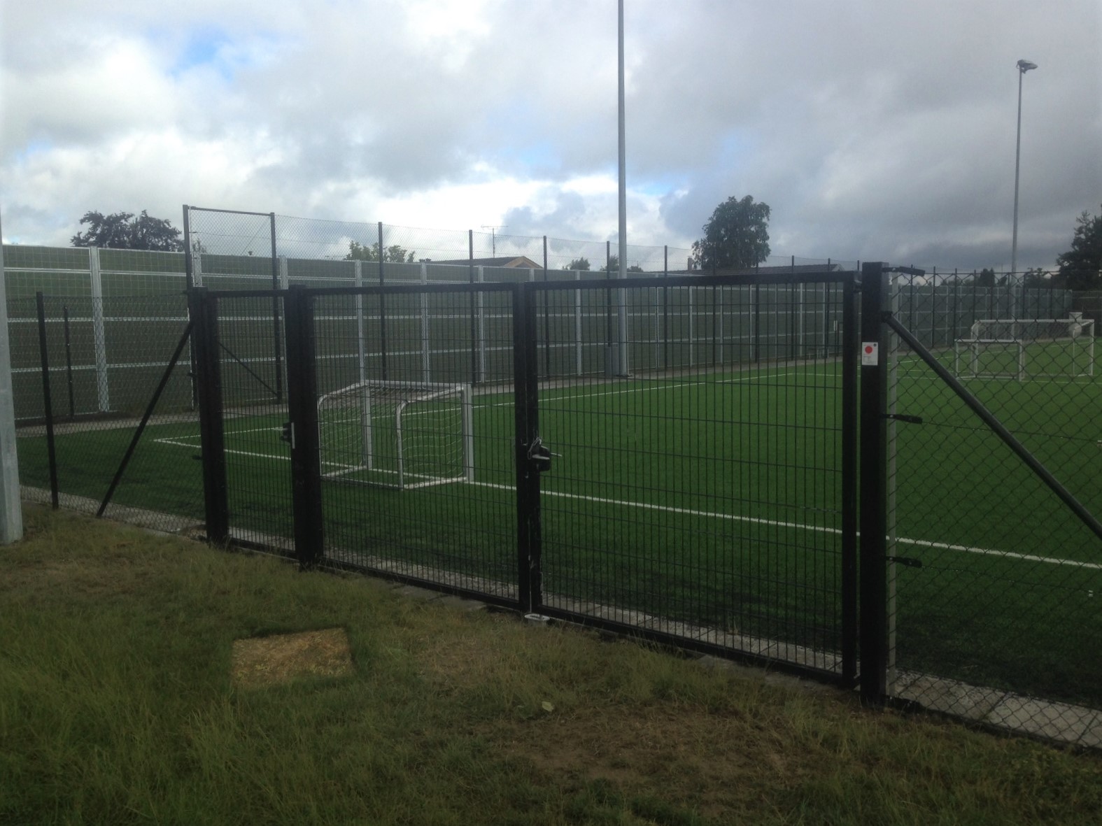 Et Noistop®-stålstøygjerde fra Poda Gjerder installert for å skjerme for støy fra en offentlig fotballbane