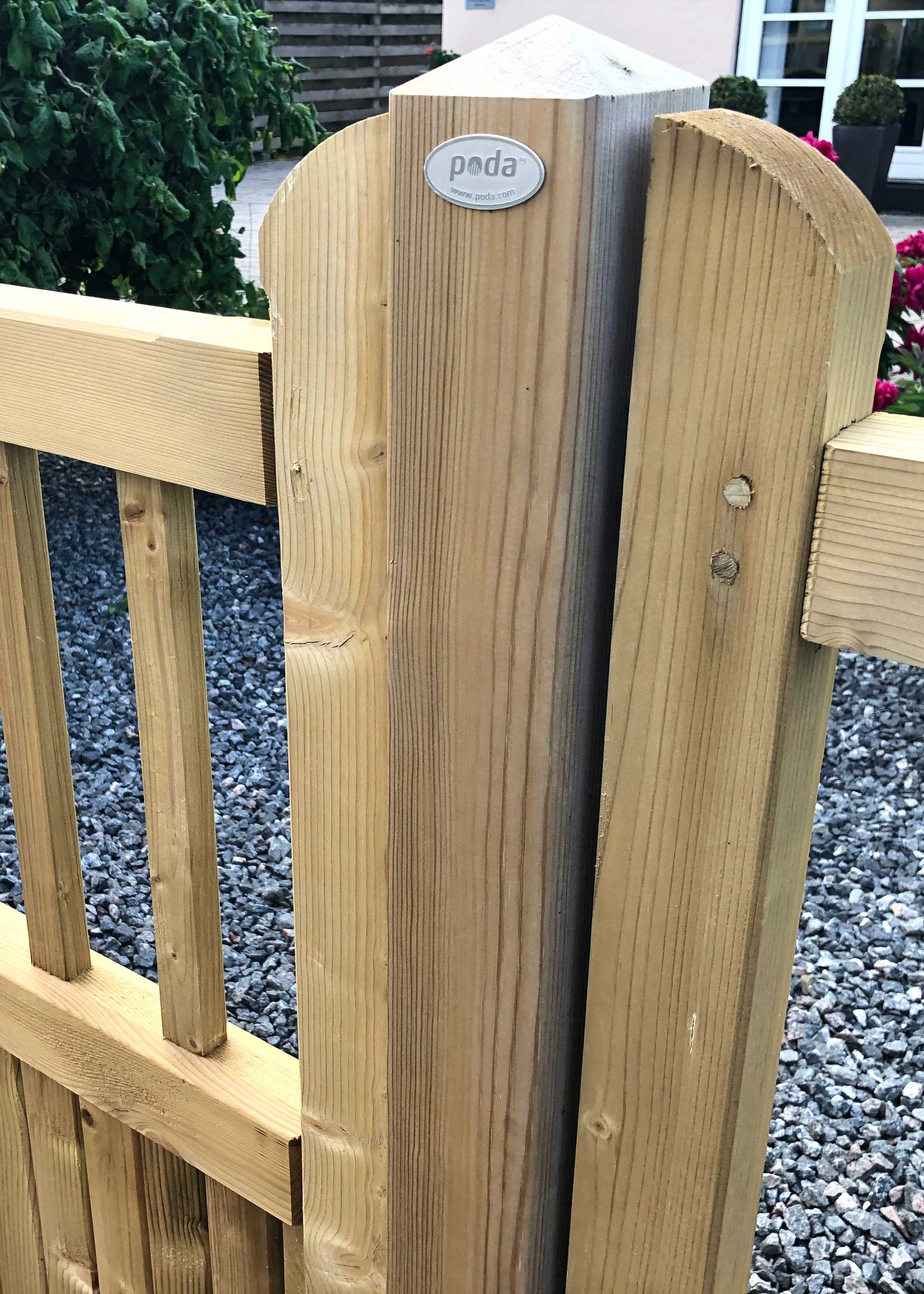 En trestolpe til Country Garden-gjerdet, med en gjerdeseksjon på begge sider